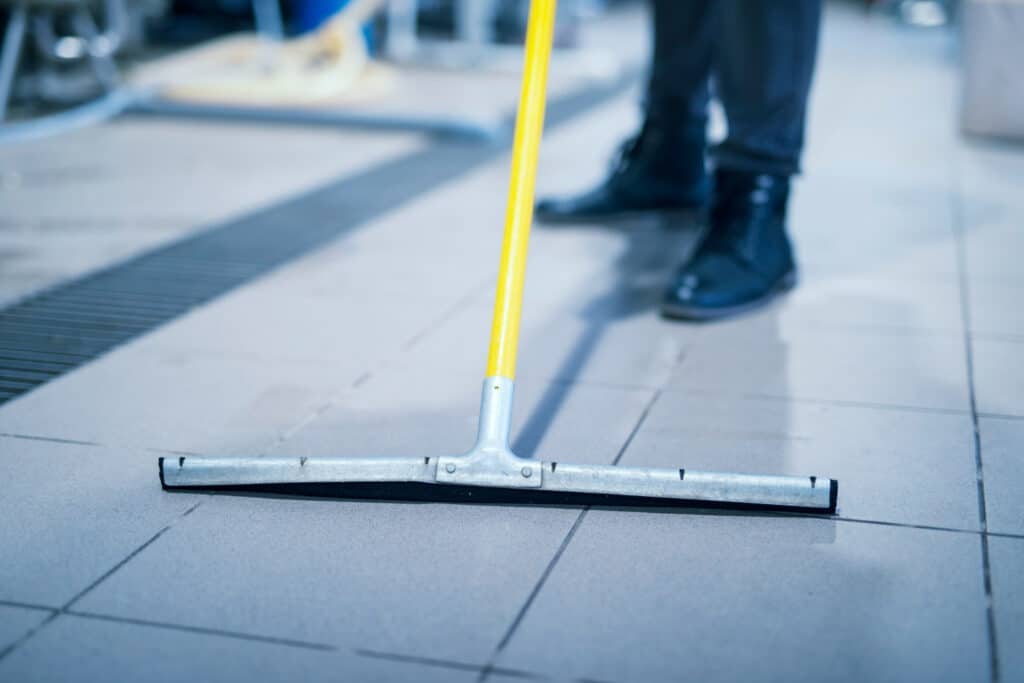 A cleaner using a floor squeegee for industrial cleaning