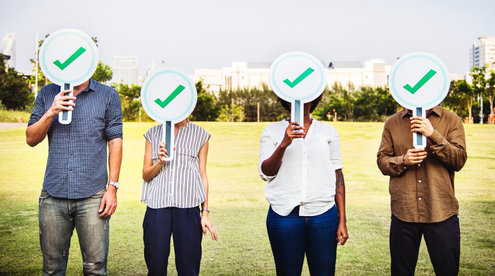 School staff holding satisfied checkmark signs for school cleaning