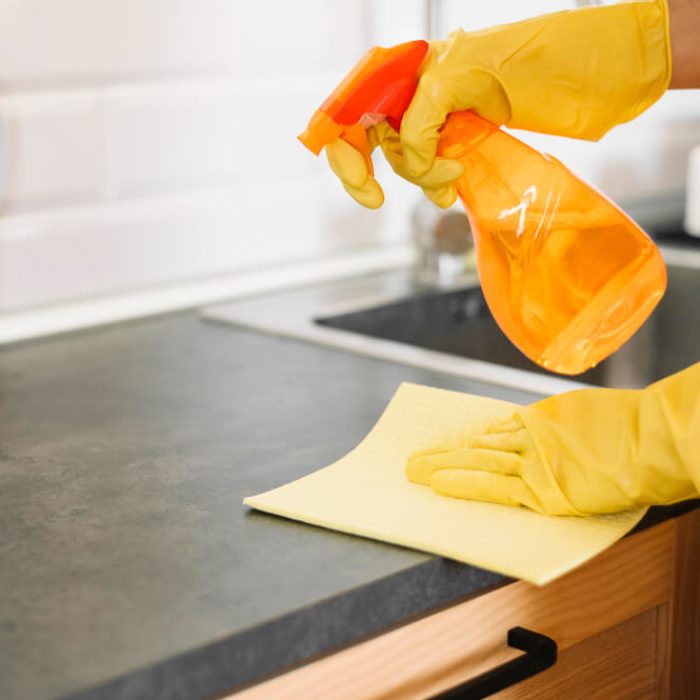 Cleaner wiping a kitchen top with eco-friendly disinfectant