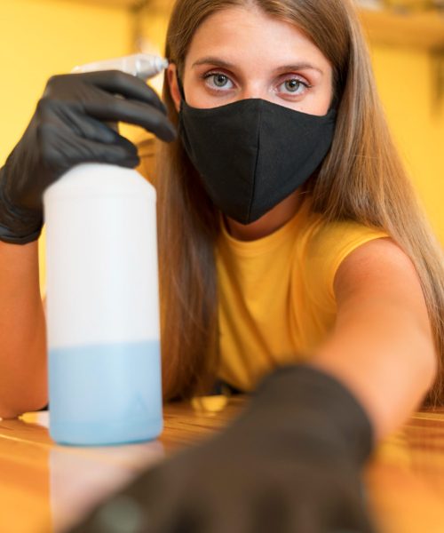 Female cleaner disinfecting cafe table for restaurant cleaning